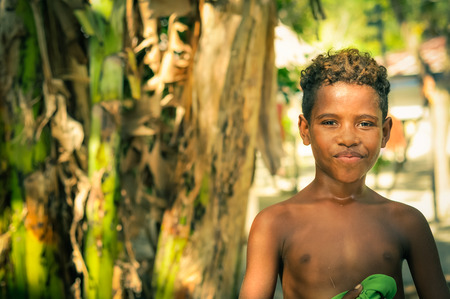 Yenbuba village, Indonesia - June 2015: Young native boy smiles and poses half-naked to photocamera at Yenbuba village at Mansuar Island, Raja Ampat, West Papua, Indonesia. Documentary editorial.のeditorial素材