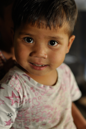 Cherapunjee, Meghalaya - March 2012: Photo of small boy with beautiful brown eyes looking to photocamera near Cherapunjee in Meghalaya. Documentary editorial.のeditorial素材