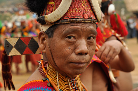 Mon, Nagaland - April 2012: Native man in traditional costume and hat poses during performance at Aoleang festival in Mon, Nagaland.  Aoleang is biggest and most significant festival of Konyak Nagas of Nagaland. Documentary editorial.のeditorial素材
