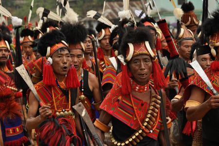 Mon, Nagaland - April 2012: Crowd of native men in costumes and hats hold rifles in their hands and sing during performance at Aoleang festival in Mon, Nagaland. Aoleang is biggest and most significant festival of Konyak Nagas of Nagaland. Documentary ediのeditorial素材