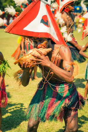 Hagen show, Papua New Guinea - circa August 2015: Young half-naked boy and plays seashell during Hagen show, Papua New Guinea. Documentary editorial.のeditorial素材