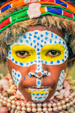 Hagen show, Papua New Guinea - circa August 2015: Young native girl with colours on her face and frowns during Hagen show, Papua New Guinea. Documentary editorial.のeditorial素材