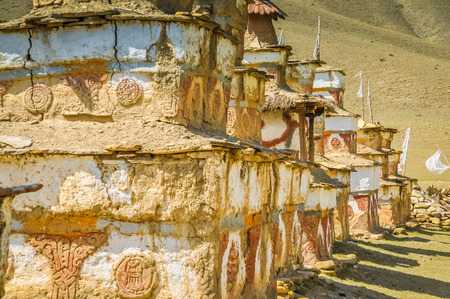 Houses made of stone and mud with ornaments and white paintings in field in Dolpo, Nepal.の写真素材