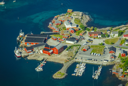 Scenic aerial view of Lofoten islands with houses of native inhabitants and harbour near coast surrounded by sea near Mount Reinebringen in Norway.の写真素材
