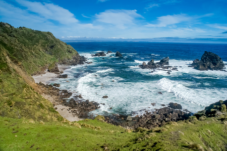 Photo of coast and rocks washed by waves of sea in Parque Nacional Chiloe in Chile.の写真素材