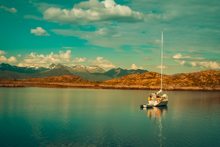 Photo of white boat sailing on lake and mountains in distance near Svolvaer in Norway.の写真素材