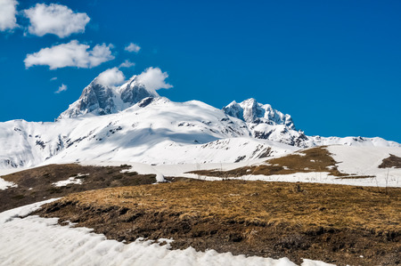 Photo of snowy mountains under blue sky in Svaneti, Georgia.