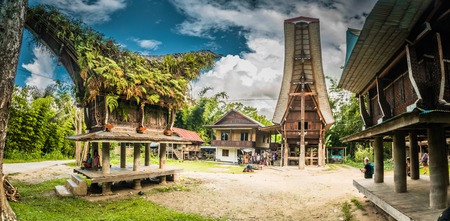 Sulawesi, Indonesia - May 2015: Photo of traditional ancestral houses with carvings, colourful ornaments and large saddleback roofs in Sangalla, Toraja region in Sulawesi, Indonesia. Documentary editorial.のeditorial素材