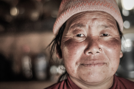Kanchenjunga Trek, Nepal - circa May 2012: Woman with cap and golden piercing in her nose in Kanchenjunga Trek, Nepal. Documentary editorial.のeditorial素材