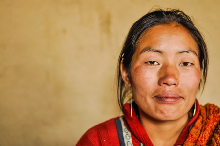 Kanchenjunga Trek, Nepal - circa May 2012: Young woman with long black hair and golden earrings in Kanchenjunga Trek, Nepal. Documentary editorial.のeditorial素材