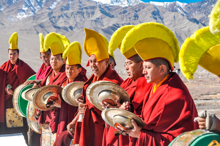 Thiksey, Ladakh - circa November 2011: Monks with yellow hats stand in row and play clash cimbals during festival at Thiksey monastery, Ladakh. Documentary editorial.のeditorial素材