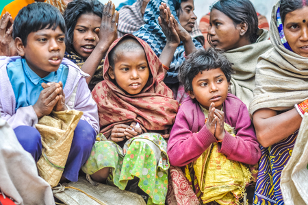 Bohdgaya, Bihar - circa January 2012: Children sit on ground and pray at school in Bohdgaya, Bihar. Documentary editorial.のeditorial素材