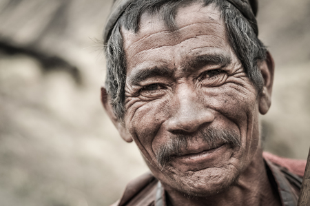 Dolpo, Nepal - circa May 2012: Old wrinkled man with grey hair and moustache smiles nicely to photocamera in Dolpo, Nepal. Documentary editorial.のeditorial素材