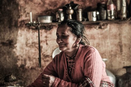 Kanchenjunga Trek, Nepal - circa May 2012: Old Native woman during preparation of meal in their simple kitchen in Kanchenjunga Trek, Nepal. Documentary editorial.のeditorial素材
