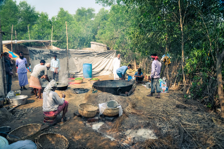 Shantiniketan, West Bengal - circa January 2012: Native women and men prepare meal during Baul music festival in Shantiniketan, West Bengal. Documentary editorial.のeditorial素材