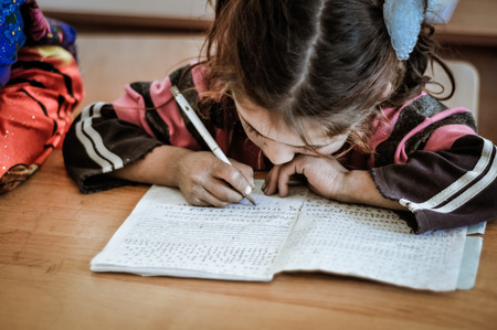 Khorog, Tajikistan - circa September 2011: Small girl learns to write properly at school in Khorog, Tajikistan. Documentary editorial.のeditorial素材