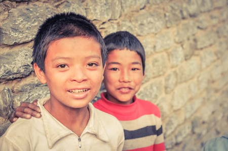 Beni, Nepal - circa May 2012: Young native black-haired brothers with brown eyes smile nicely to photocamera in streets of Beni, Nepal. Documentary editorial.のeditorial素材