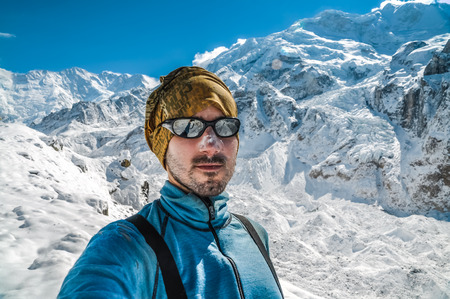 Kanchenjunga Trek, Nepal - circa May 2012: Photo of tourist with sunglasses in beautiful snowy mountains in Kanchenjunga Trek, Nepal. Documentary editorial.のeditorial素材