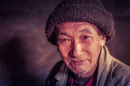 Tuting, Arunachal Pradesh - circa March 2012: Native man with brown cap on his head smiles in Tuting, Arunachal Pradesh. Documentary editorial.のeditorial素材