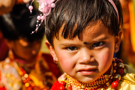 Shillong, Meghalaya - circa April 2012: Small girl with pink headband with flower and black dot on forehead at Shad Suk Mynsiem Festival in Shillong, Meghalaya. Documentary editorial.のeditorial素材