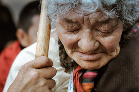 Bohdgaya, Bihar - circa January 2012: Old woman with closed eyes and grey hair holds wooden stick and looks down in Bohdgaya, Bihar. Documentary editorial.のeditorial素材