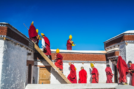 Thiksey, Ladakh - circa November 2011: Monks with typical yellow hats go upstairs during ceremony at Thiksey monastery, Ladakh. Documentary editorial.のeditorial素材