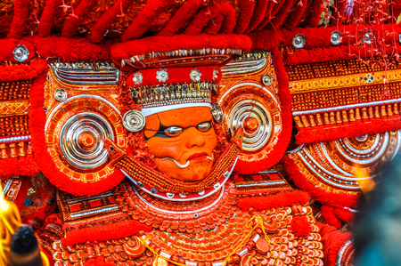 Thottada, south of Kannur, Kerala - circa January 2012: Mask of dancer with ornaments during Theyyam near Thottada, south of Kannur, Kerala. Documentary editorial.のeditorial素材