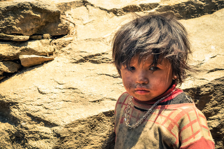 Kanchenjunga Trek, Nepal - circa May 2012: Small girl with dirt on her face and with necklace made of beads in Kanchenjunga Trek, Nepal. Documentary editorial.のeditorial素材