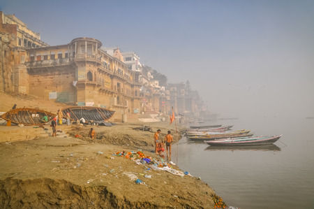 Varanasi, Uttar Pradesh - circa January 2012: Native people stand by river near ships in foggy morning in Varanasi, Uttar Pradesh. Documentary editorial.のeditorial素材