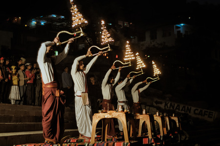 Rishikesh, Uttarakhand - circa January 2012: Young men stand by river and hold golden candlestands with candles above their heads during ceremony in Rishikesh, Uttarakhand. Documentary editorial.のeditorial素材