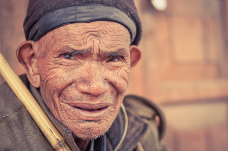 Ziro, Arunachal Pradesh - circa March 2012: Old man with tanned face and wrinkles wears cap on his head in Ziro, Arunachal Pradesh. Documentary editorial.のeditorial素材