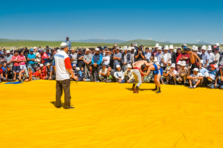 Karkara, Kyrgyzstan - circa August 2011: Native men wrestle at Independence day festival in Karkara. Documentary editorial.のeditorial素材