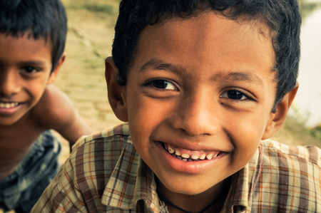 Chittagong, Bangladesh - circa July 2012: Young smiling boys with brown hair and brown eyes smile nicely to photocamera in rural village near Chittagong, Bangladesh. Documentary editorial.のeditorial素材