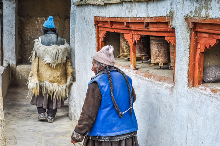 Lamayuru, Ladakh - circa November 2011: Old women in traditional clothes with long braids of hair at Lamayuru monastery, Ladakh. Documentary editorial.のeditorial素材