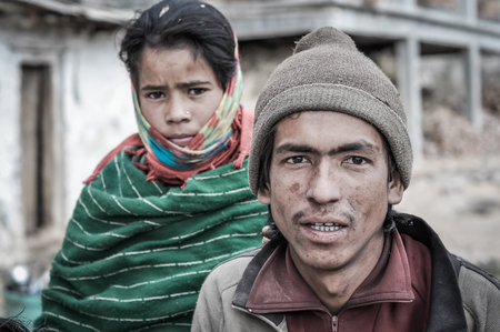 Kuari pass, Uttarakhand - circa December 2011: Native man with brown cap poses with his daughter dressed in green clothes in mountainous region in Kuari pass, Uttarkhand. Documentary editorial.のeditorial素材