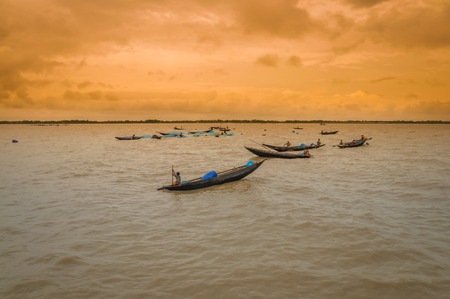 Sunderban, Bangladesh - circa July 2012: Photo of native people in wooden boats on river and fishing in Sunderban, Bangladesh. Documentary editorial.のeditorial素材