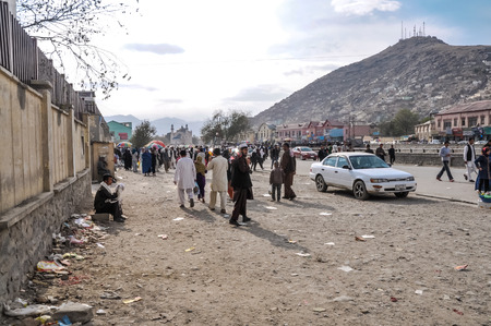 Kabul, Afghanistan - circa October 2011: Photo of people and white car at market in Old town, old city part in Kabul. Documentary editorial.のeditorial素材