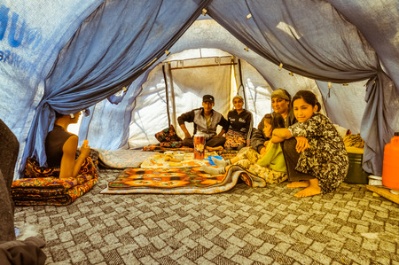 Arslanbob, Kyrgyzstan - circa July 2011: Native family sits on the ground in big tent during lunch in Arslanbob, Kyrgyzstan. Documentary editorial.のeditorial素材