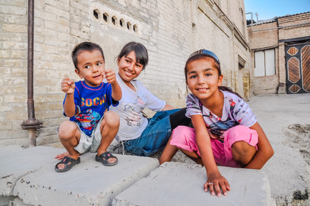 Bukhara, Uzbekistan - circa July 2011: Young native children pose in streets of Bukhara, Uzbekistan. Documentary editorial.のeditorial素材