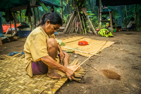 Mashaquipe, Bolivia - circa June 2009: Native woman sits on ground and weaves mat at Mashaquipe, Bolivia. Documentary editorial.のeditorial素材