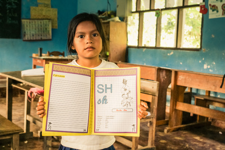 Villa Alcira, Bolivia -circa June 2009: Native girl holds her exercise book at school at Villa Alcira, Bolivia. Documentary editorial.のeditorial素材
