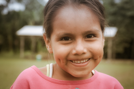 Villa Alcira, Bolivia - circa June 2009: Young girl with beautiful smile and with dimples poses at Villa Alcira, Bolivia. Documentary editorial.のeditorial素材