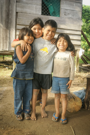 Villa Alcira, Bolivia - circa June 2009: Four smiling siblings pose in front of their house at Villa Alcira, Bolivia. Documentary editorial.のeditorial素材