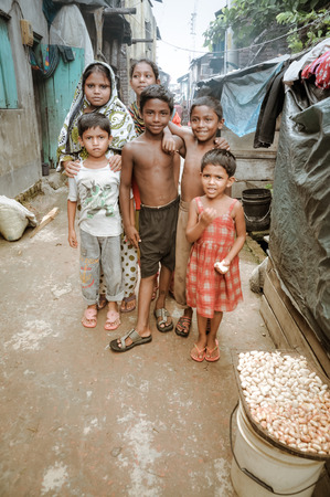 Khulna, Bangladesh - circa July 2012: Group of six young children pose in street and look curiously...