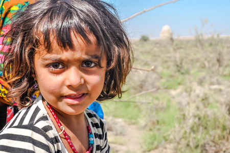 Merv, Turkmenistan - circa July 2011: Small native child frowns in ancient city of Merv, Turkmenistan. Documentary editorial.のeditorial素材