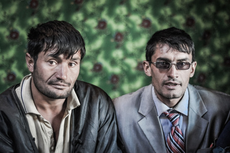 Khorog, Tajikistan - circa September 2011: Two native men pose in Khorog, Tajikistan. Man on the right side wears sunglasses and suit. Documentary editorial.のeditorial素材