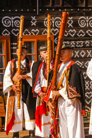 ÄiÄmany, Slovakia - circa September 2009: Three Slovak men dressed in folk costume play fujara at folk festival in ÄiÄmany. Documentary editorial.のeditorial素材