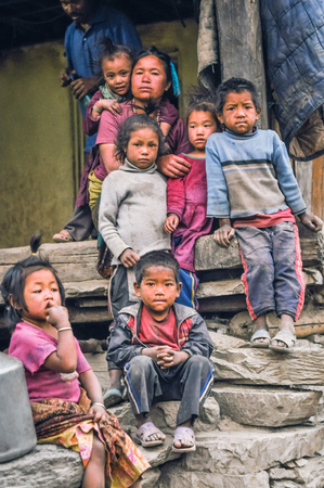 Dolpo, Nepal - circa May 2012: Photo of native woman sitting in front of her house with her six young children in Dolpo, Nepal. Documentary editorial.のeditorial素材