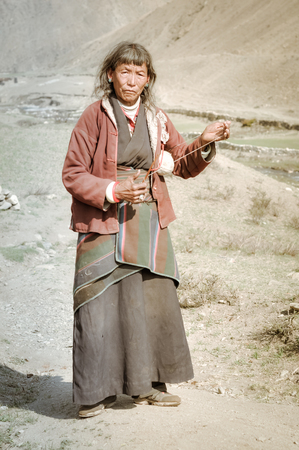 Dolpo, Nepal - circa June 2012: Old grey-haired woman with wrinkled face wears red jacket in Dolpo, Nepal. Documentary editorial.のeditorial素材