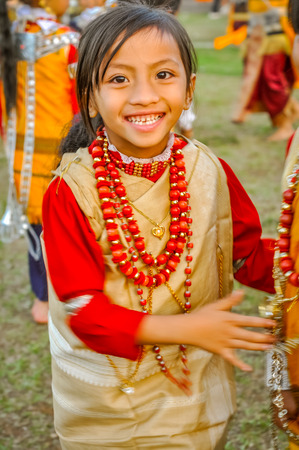 Shillong, Meghalaya - circa April 2012: Small girl in simple costume with red necklaces made of beads at Shad Suk Mynsiem Festival in Shillong, Meghalaya. Documentary editorial.のeditorial素材